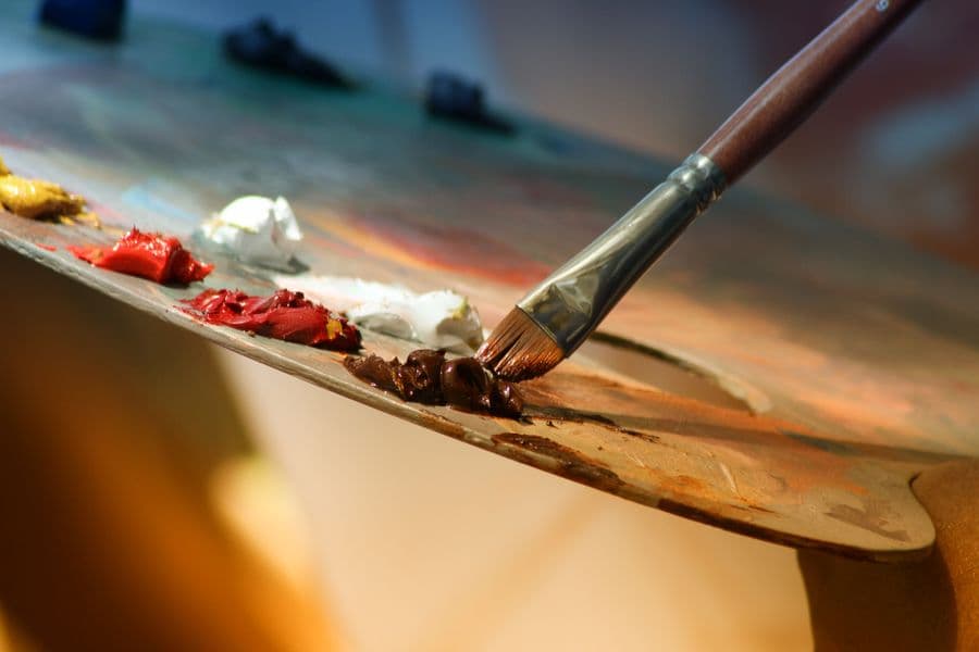 A paintbrush and palette on a work surface